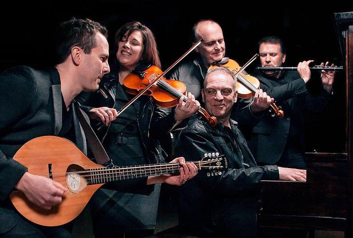 The Barra MacNeils performing with a mandolin, violins, and piano.