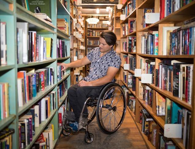 Man in Wheelchair exploring bookshelf