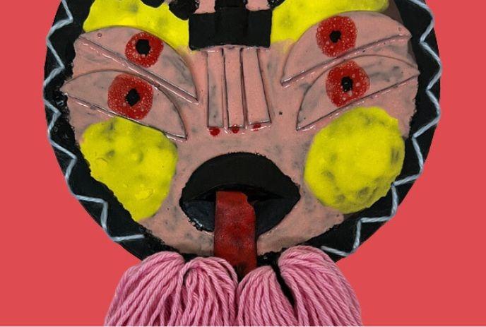 A colorful abstract mask with bold patterns and bright accents against a red background.