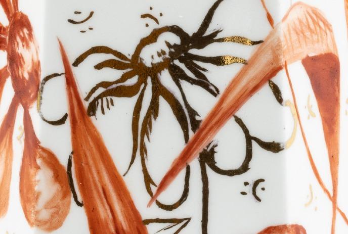 A decorative pattern of abstract floral designs in brown, orange, and gold on a white background.