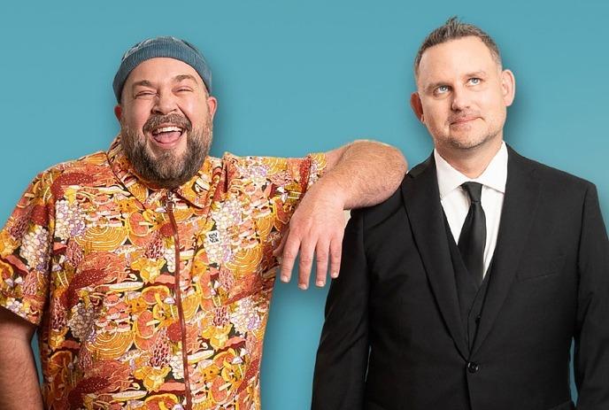 Darcy & Jer posing for the camera in front of a blue background.