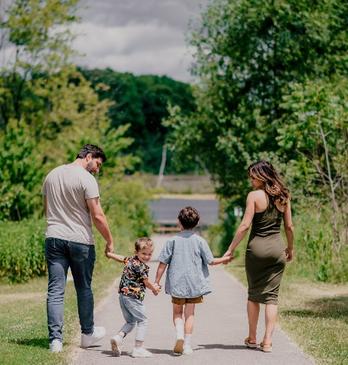 A family of four walking on a park trail in London, Ontario.