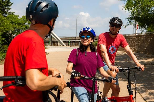 A person is giving a tour to two individuals by bike at a location in London, Ontario