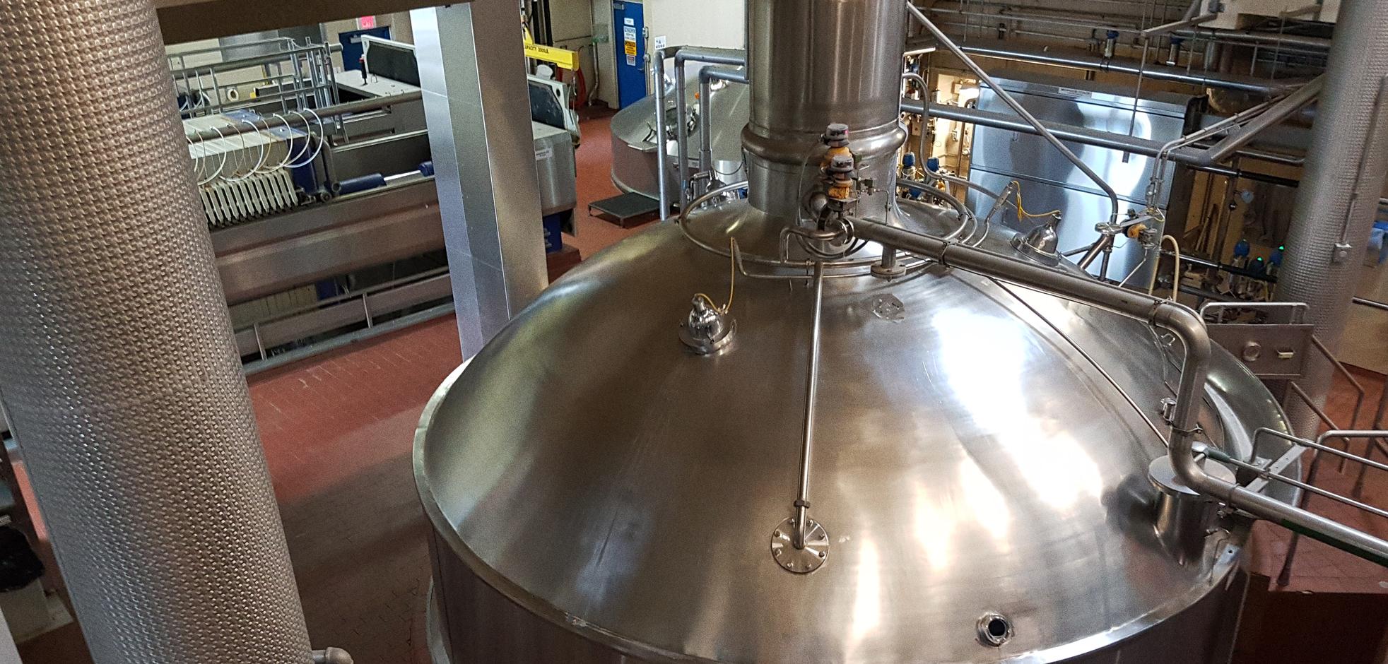 Large vat on factory floor used for brewing.