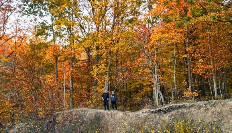 Two hikers stand at a lookout on a trail at Longwoods Road Conservation Area near London, Ontario.
