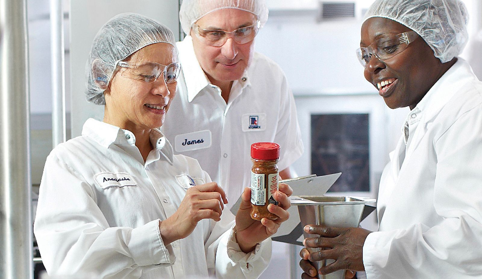people in white clothing looking at a spice bottle