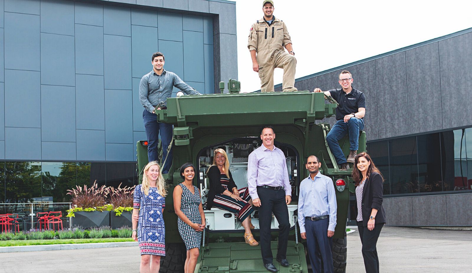 people standing around military vehcile