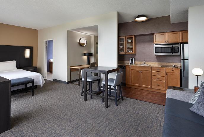 Open studio apartment with bed, dining table, kitchenette, and cozy living area.