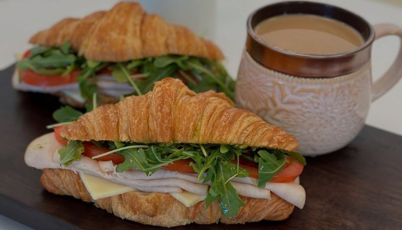 Plated brunch: eggs benedict, fried chicken & waffles, sunny egg dish—served on a wooden table.