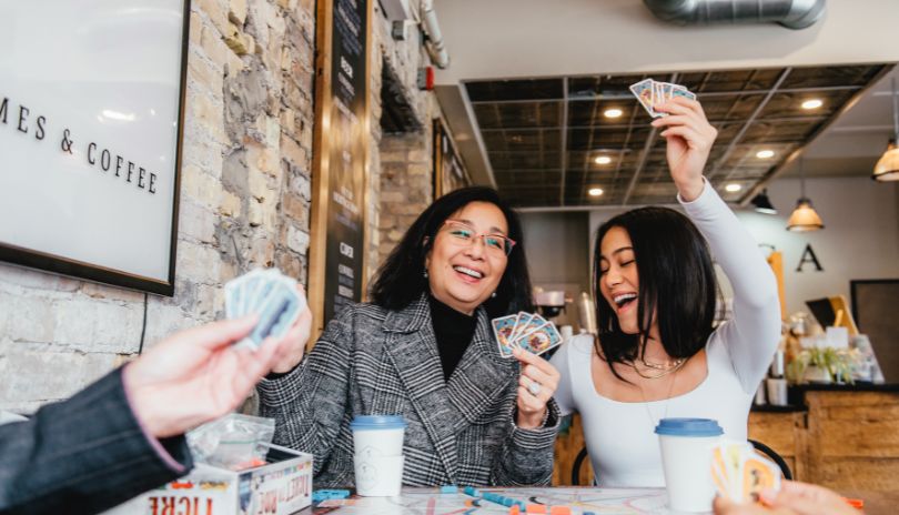 A family enjoying a card game and drinking coffee atSaga Board Games & Coffee located in London, Ontario