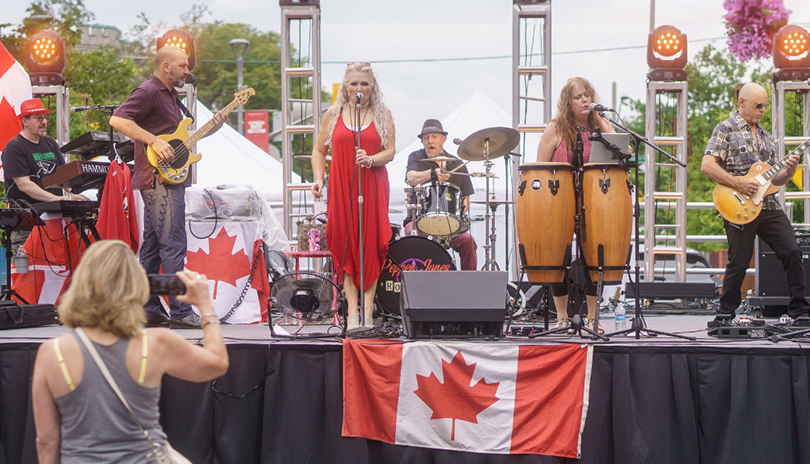 Band performing surrounded by Canadian flags