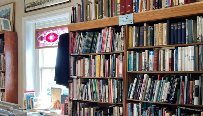 A well-stock bookshop with a stained glass window.