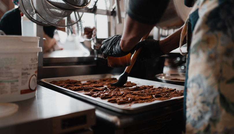 Chef marinating fine cuisine on the prep table of yaya's kitchen